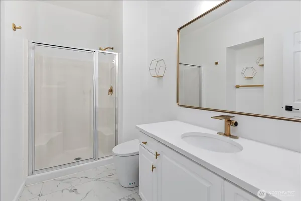 a bathroom with a sink a toilet and shower