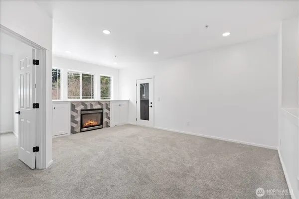 an empty room with fireplace and windows