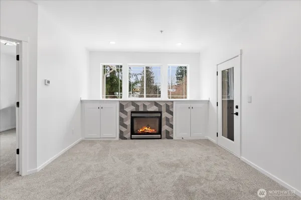 an empty room with windows and fireplace