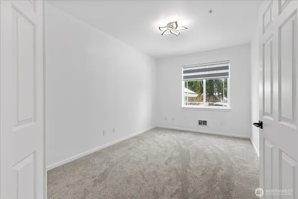 an empty room with windows and closet