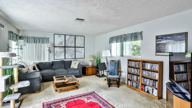 a living room with furniture a bookshelf and a window