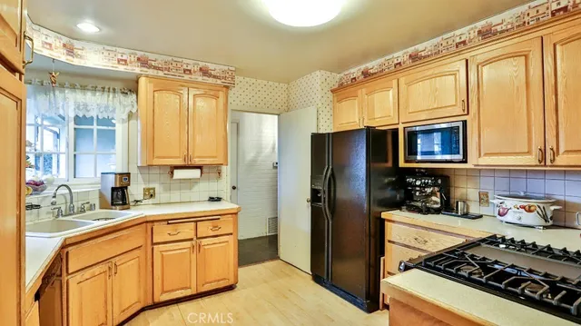 a kitchen with stainless steel appliances a stove a sink and a refrigerator