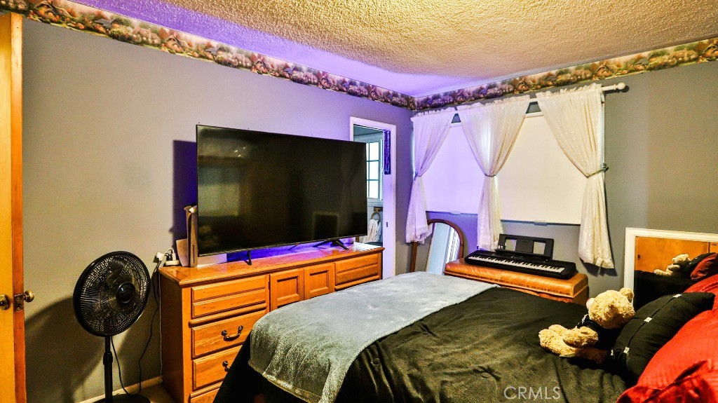 428 West 8th Street Upland, CA 91786 - Photo 34 of 50 a bedroom with a bed and a flat screen tv
