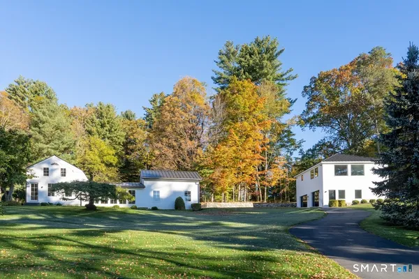 a front view of a house with a garden and trees