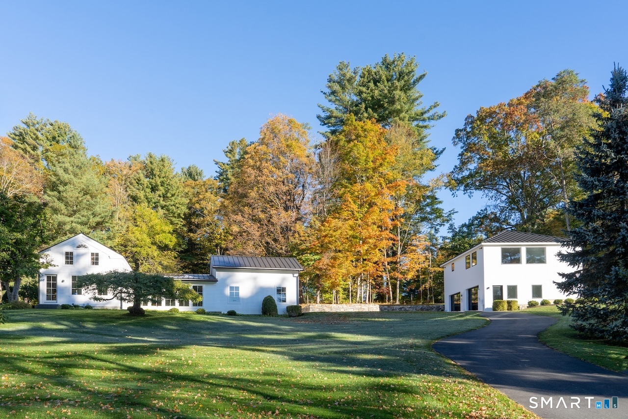a front view of a house with a garden and trees
