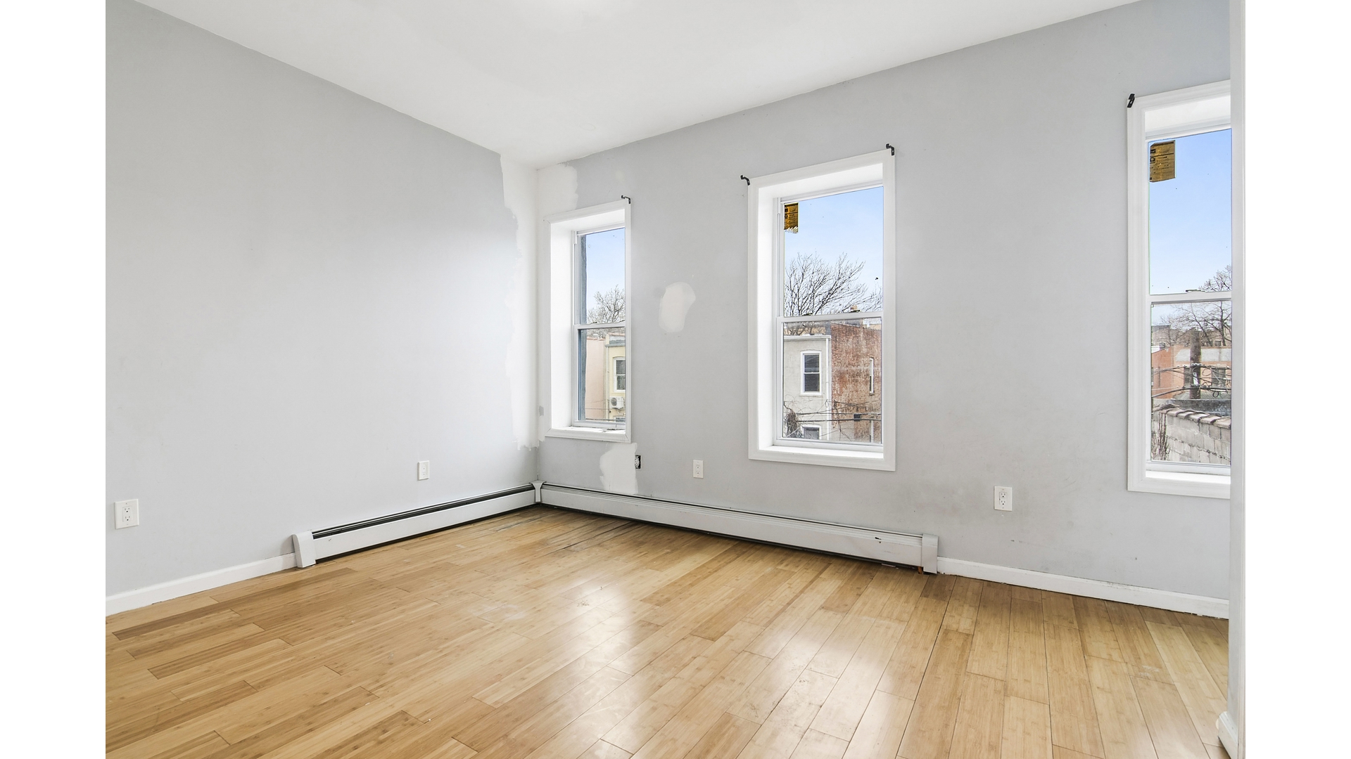 2001 Strauss Street, Unit 2 Brooklyn, NY 11212 - Photo 4 of 6 a view of an empty room with wooden floor and a window