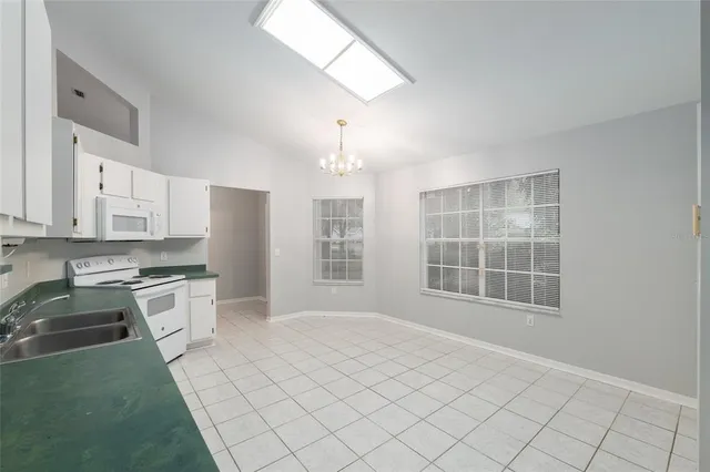 a kitchen with granite countertop a stove a sink and a refrigerator