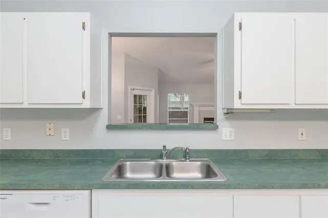 a kitchen with granite countertop a sink and cabinets