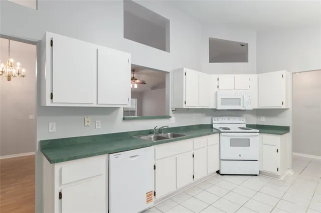 a kitchen with white cabinets and white appliances