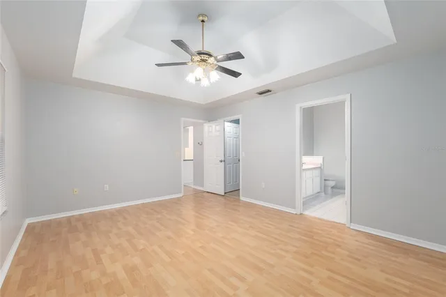 a view of an empty room and chandelier fan