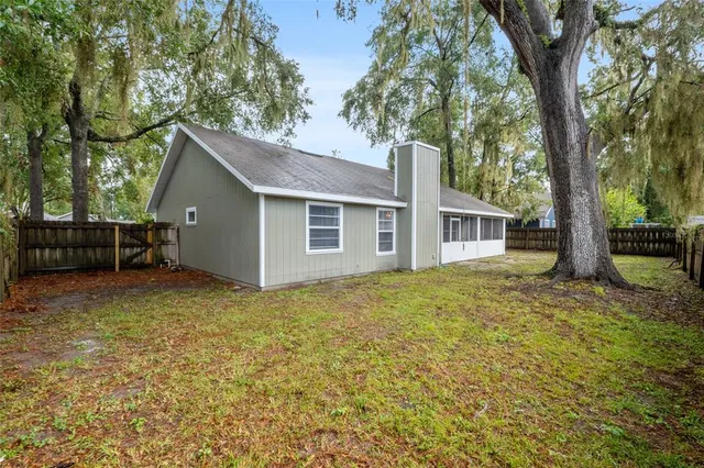 a view of a house with backyard and a tree