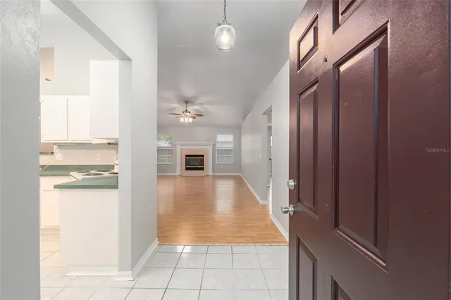a view of a hallway with wooden floor and a living room