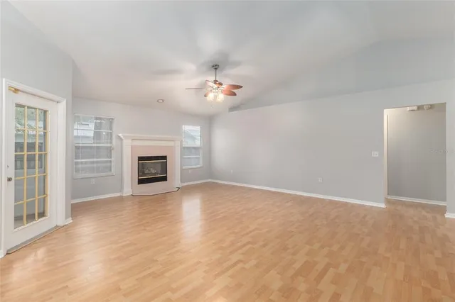 a view of an empty room with a fireplace and a window