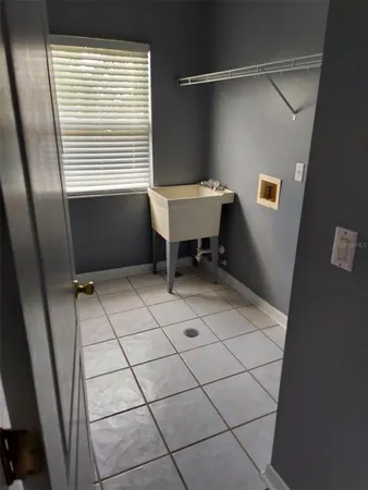 a view of a livingroom with a chandelier fan and windows