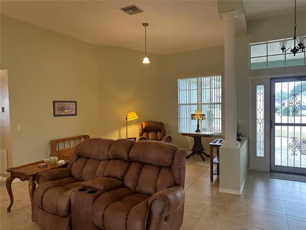 a living room with furniture a chandelier and a window