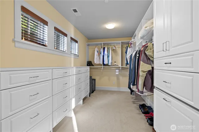 a view of walk in closet with clothes and shoes