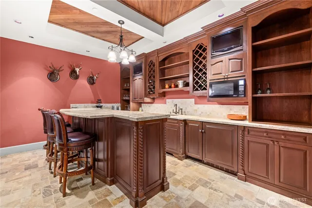 a dining hall with stainless steel appliances granite countertop a sink and a wooden cabinets