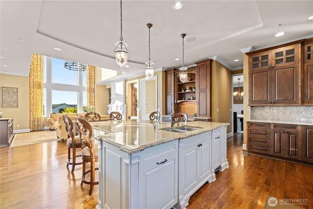 a large kitchen with kitchen island granite countertop a large window and stainless steel appliances