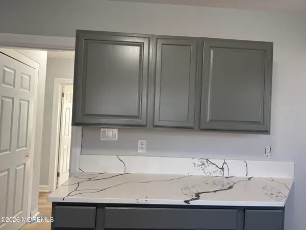 a large kitchen with granite countertop a stove top oven a sink dishwasher and a refrigerator with wooden floor