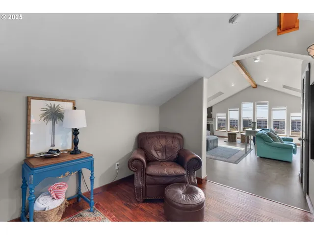 a living room with furniture a large window wooden floor and a chandelier