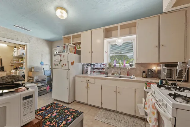 a kitchen with stainless steel appliances a stove a sink and a refrigerator