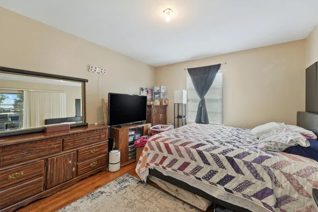 a bedroom with a bed and wooden floor