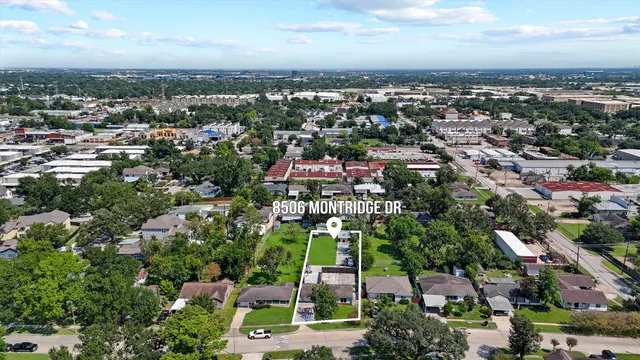 an aerial view of residential houses with city and green space