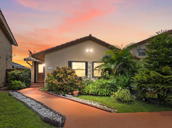 a front view of a house with a yard and potted plants