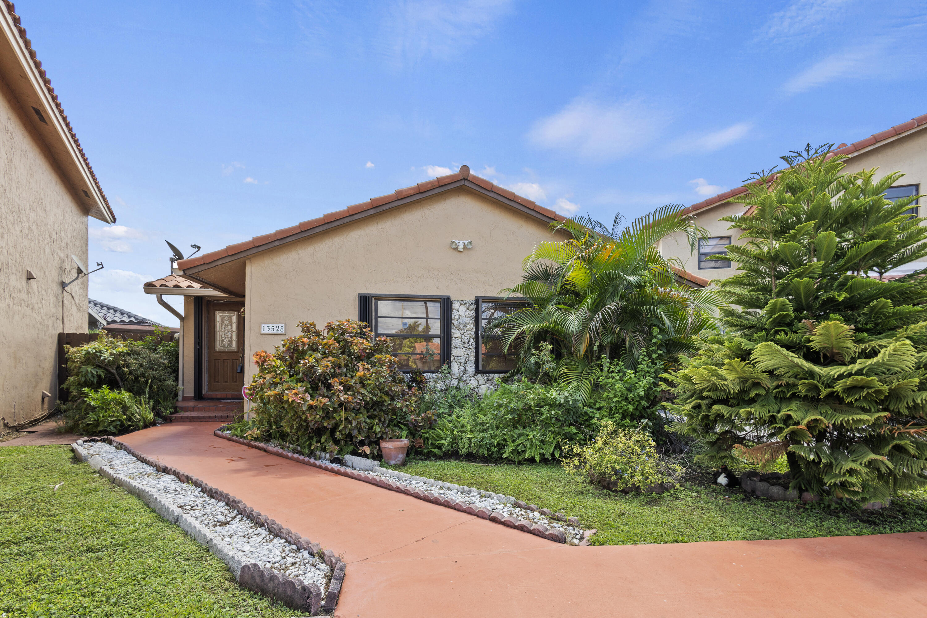 13528 Southwest 9th Lane Miami, FL 33184 - Photo 2 of 24 a front view of a house with a yard and potted plants
