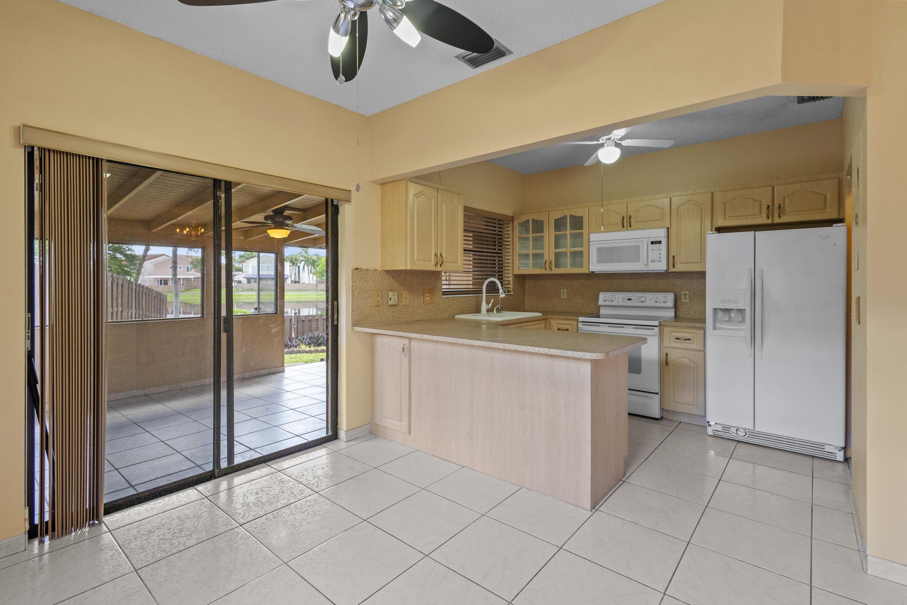 13528 Southwest 9th Lane Miami, FL 33184 - Photo 6 of 24 a kitchen with a refrigerator a sink and a stove top oven