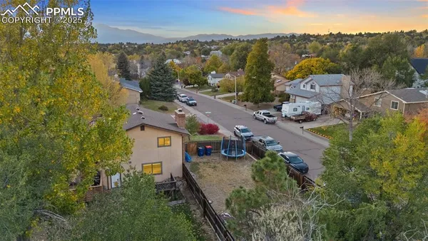 an aerial view of a house with a garden and lake view
