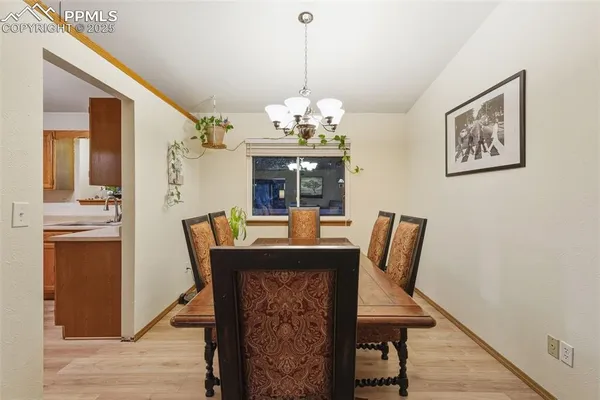 a dining room with furniture a chandelier and wooden floor