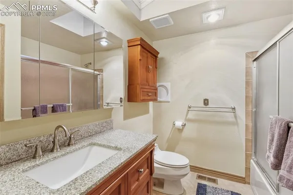 a bathroom with a granite countertop sink toilet and shower