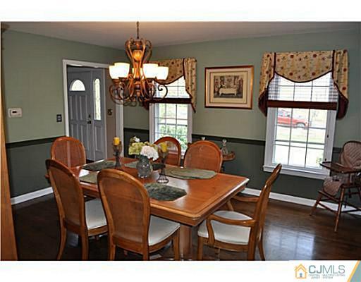152 Mountainview Road Warren, NJ 07059 - Photo 5 of 10 a dining room with wooden floor a chandelier a wooden table and chairs