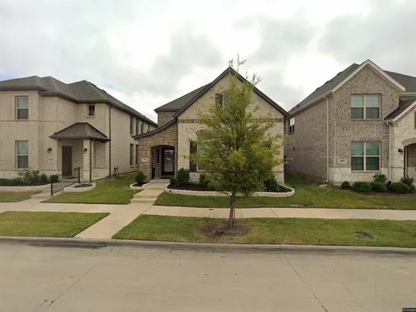 a view of a white house with a yard next to a road