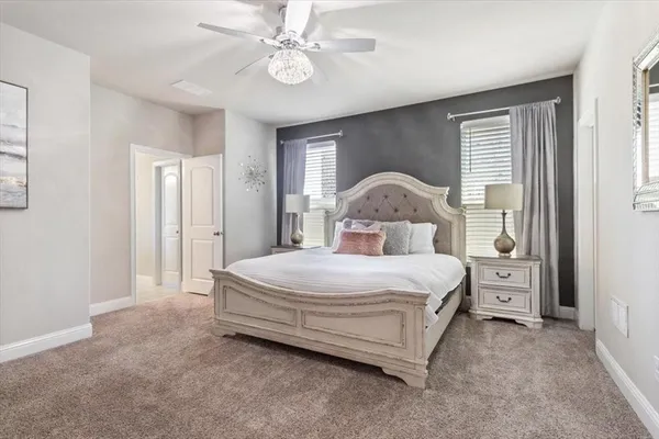 a spacious bedroom with a bed and a chandelier