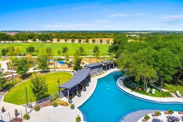 a view of a swimming pool with a chairs and table in a patio