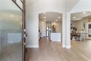 a view of a hallway with wooden floor a glass table and chairs