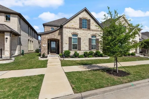 a front view of a house with a yard and potted plants