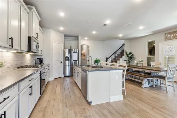 a kitchen with stainless steel appliances a stove top oven and a refrigerator