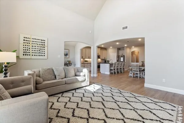 a living room with furniture and a dining table with a large window