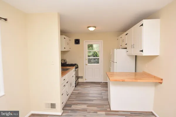 a kitchen with granite countertop white cabinets and white appliances