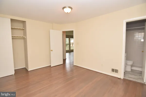 an empty room with wooden floor and entrance