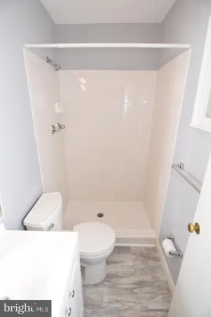 a white toilet sitting next to a bath tub