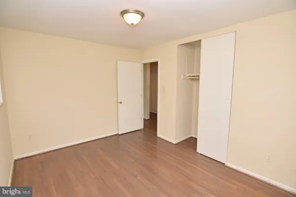 an empty room with wooden floor and closet