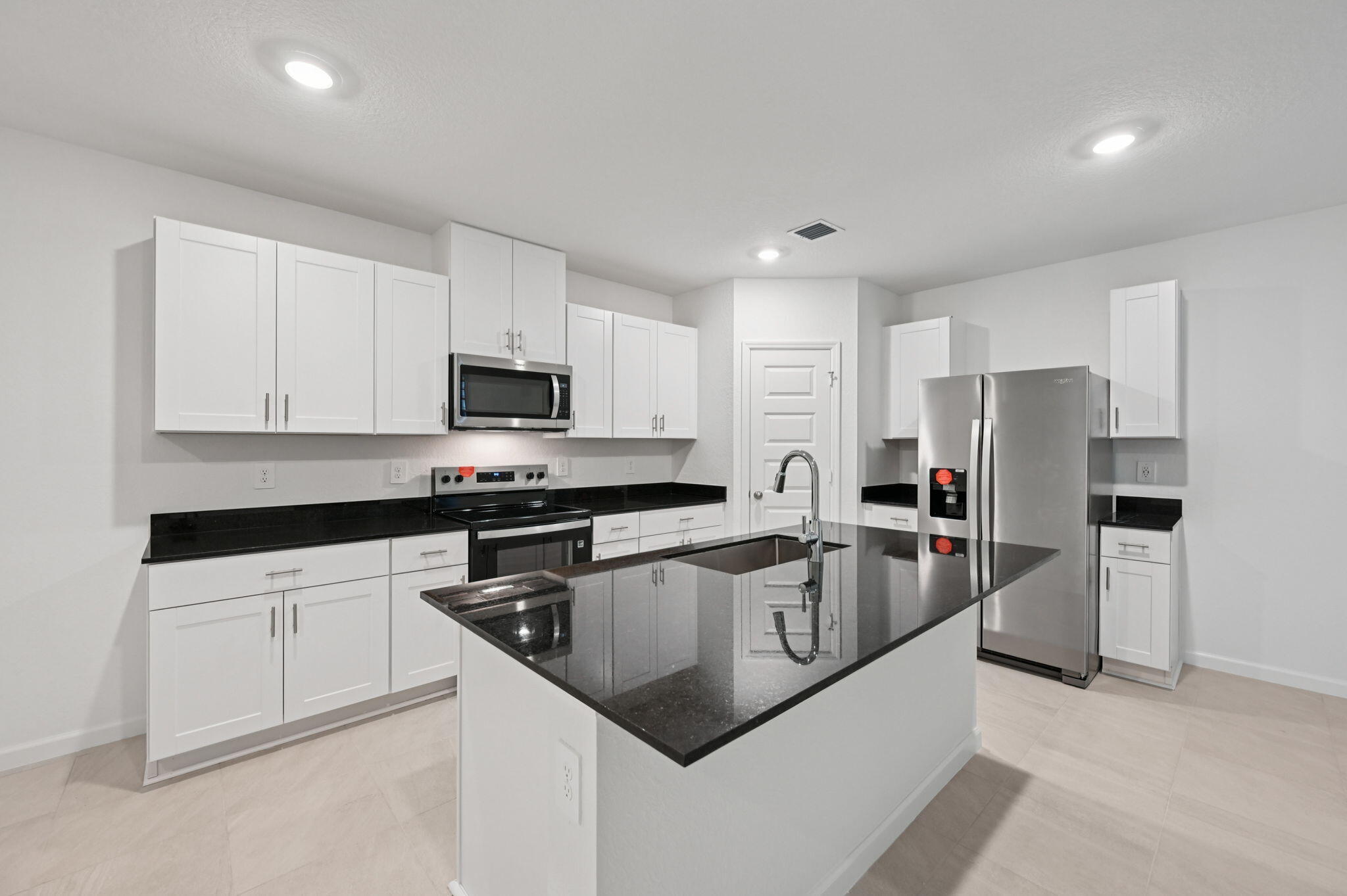 14202 Southwest New Dawn Road Indiantown, FL 34956 - Photo 10 of 27 a kitchen with stainless steel appliances granite countertop a sink stove and refrigerator