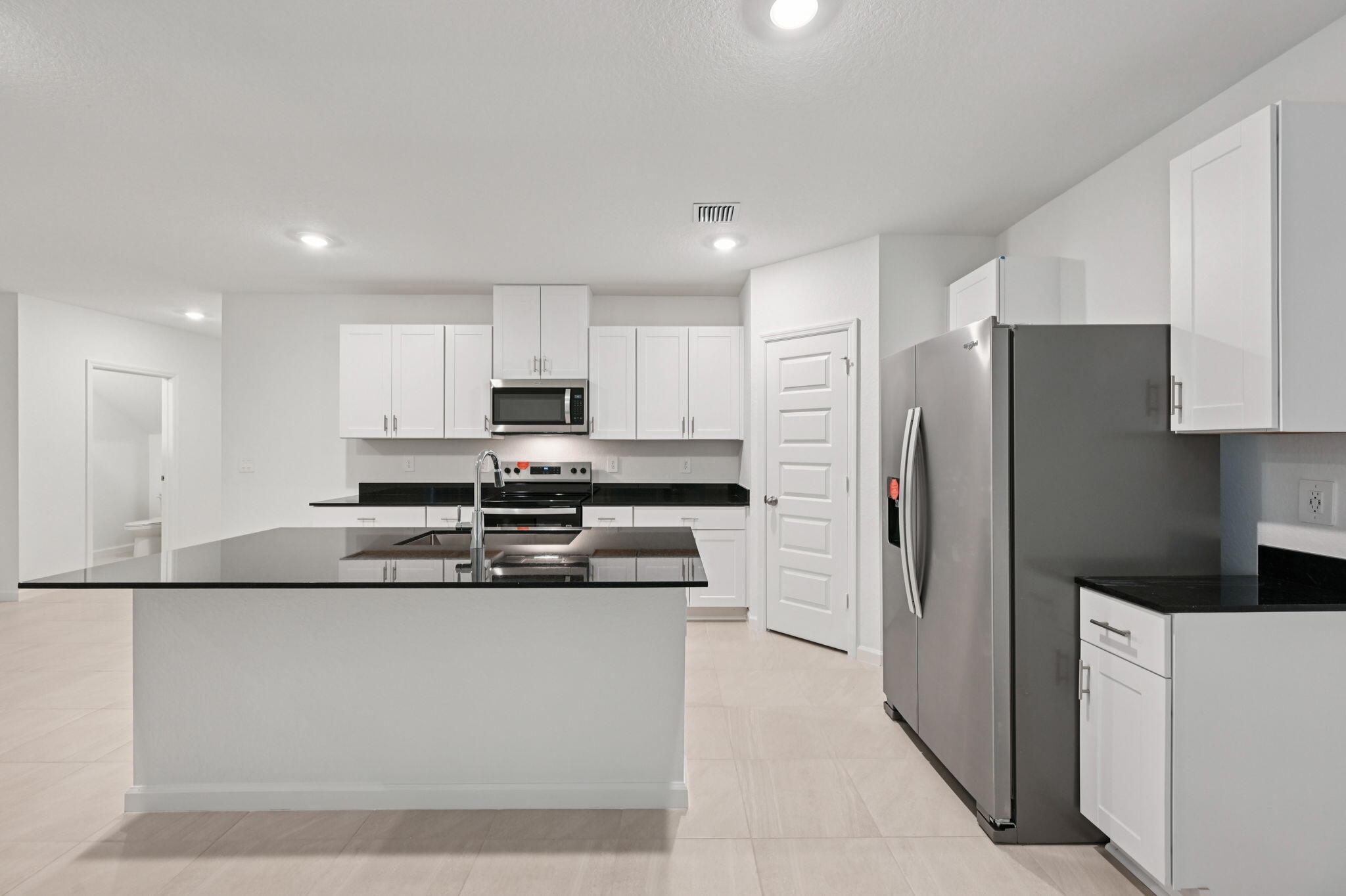 14202 Southwest New Dawn Road Indiantown, FL 34956 - Photo 11 of 27 a large kitchen with stainless steel appliances granite countertop a refrigerator a stove a sink and a granite counter tops