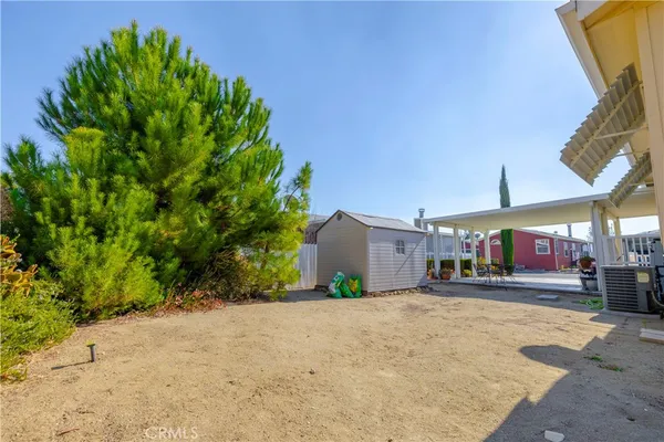 a front view of a building with a yard and trees