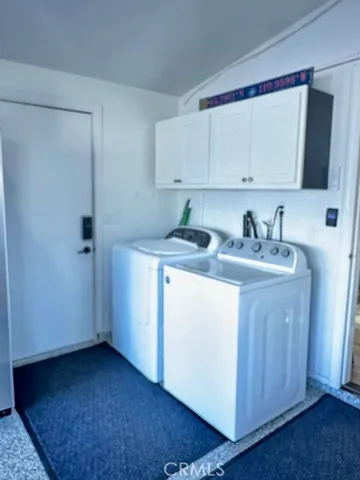 a utility room with cabinets washer and dryer