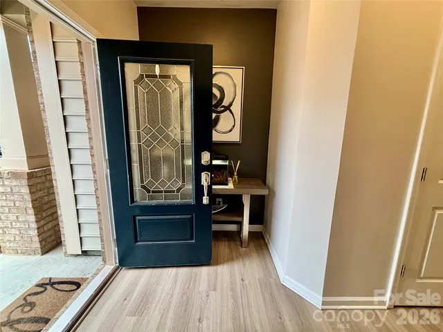 a kitchen with stainless steel appliances a stove top oven a refrigerator a sink and a dining table with wooden floor